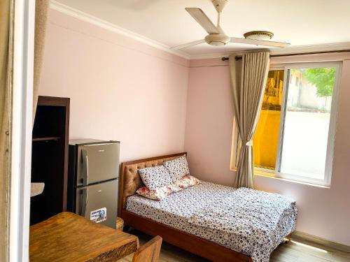 a small bedroom with a bed and a window at Tajiri Studio Flats - Mbezi Beach - Comfort, Convenience, Privacy and Security Guaranteed in Dar es Salaam