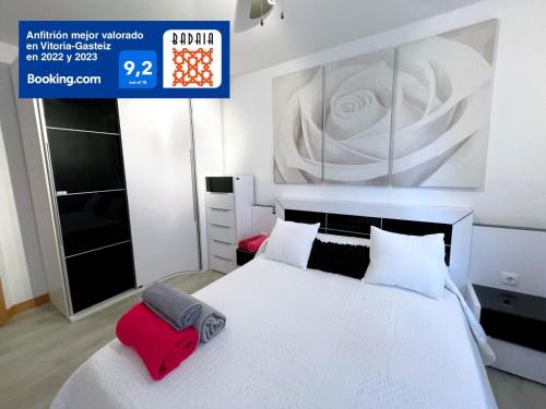 1 dormitorio con 1 cama blanca y una gran pintura en la pared en A las puertas de la Catedral 90m2 con Garaje, en Vitoria-Gasteiz