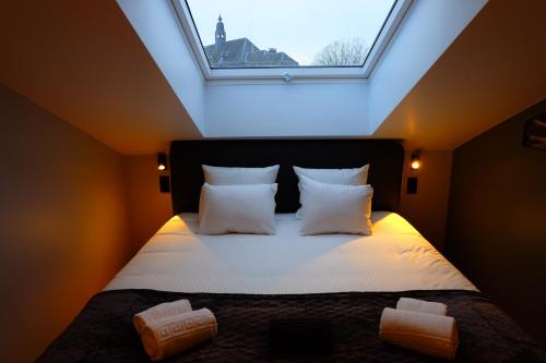 a bedroom with a bed with a large window at Le Cerf d'Or in Herbeumont