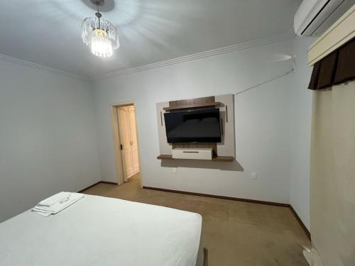 um quarto com uma televisão e uma cama em Suíte de Luxo no centro, com hidromassagem e closet em Sinop