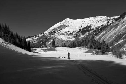 a person standing in the snow in front of a mountain at Isov Ranch in Plav