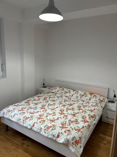1 dormitorio con 1 cama con edredón de flores en Modern Apartment with Panoramic City Views, en Skopje