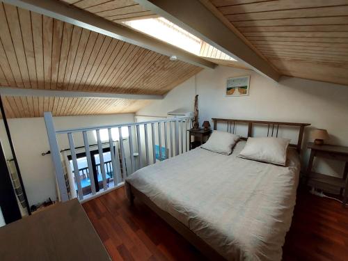 ein Schlafzimmer mit einem Bett und einer Holzdecke in der Unterkunft Studio Mezzanine Piscine presqu'île de Giens in Hyères