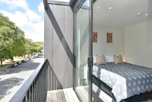 a bedroom with a bed on a balcony at Worcester Terrace 201 in Christchurch