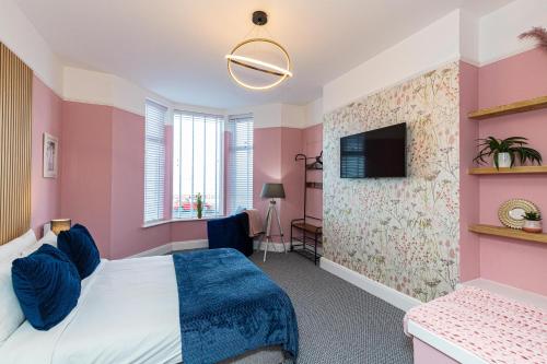 a bedroom with a bed and a tv on a wall at Beachfront Apartment 3 Bedrooms Sleeps 7 - Gateway to the Lake District - Newly Refurbished in Morecambe