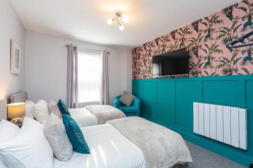 a bedroom with two beds and a tv on the wall at Beachfront Apartment 3 Bedrooms Sleeps 7 - Gateway to the Lake District - Newly Refurbished in Morecambe
