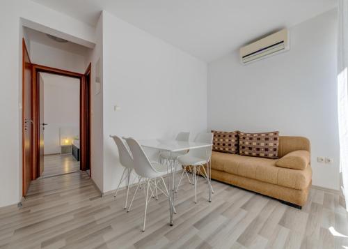 a living room with a table and chairs and a couch at Apartments Podstrana with shared Pool in Podstrana