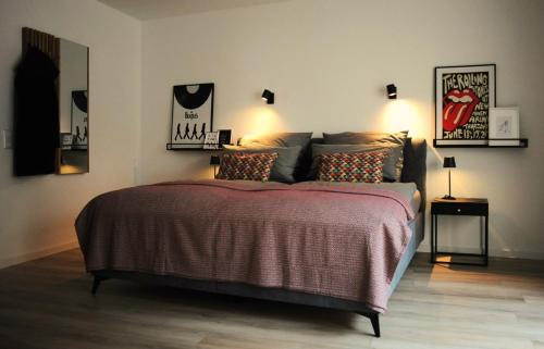 a bedroom with a large bed with two lamps at Deluxe-Apartment Altstadt in Ettlingen
