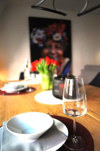a wooden table with a glass of wine on a table at Deluxe-Apartment Altstadt in Ettlingen