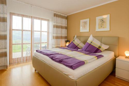 um quarto com uma cama grande e almofadas roxas em Fewo-Harlachberg-Blick-1 em Bodenmais