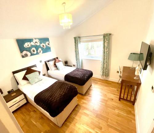 1 dormitorio con 2 camas y ventana en The Applewood Lodge en Heytesbury