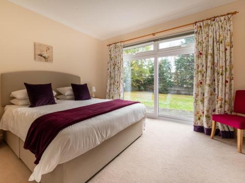 um quarto com uma cama e uma grande janela em 5 Bed in Woodbridge 72724 em Woodbridge