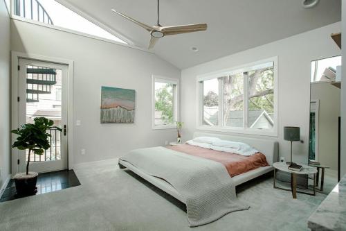 una camera bianca con un grande letto e finestre di Linden Hills Designer Retreat a Minneapolis