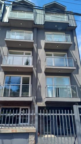 een appartementencomplex met ramen en een balkon bij Departamentos del oeste in Bariloche