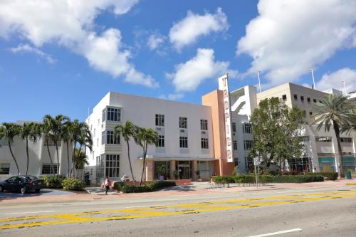 a white building on a city street with palm trees at Tropics Hotel Miami Beach in Miami Beach