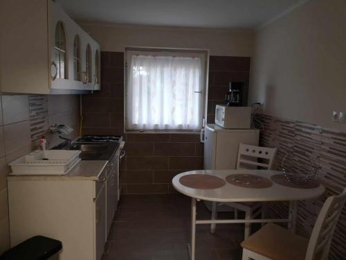 a small kitchen with a table and a refrigerator at Kiss Apartman in Balatonboglár