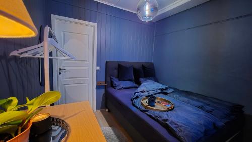 Dormitorio azul con cama y mesa en Moderne cityleilighet Sogndal en Sogndal