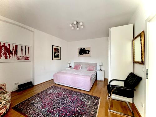 een slaapkamer met een bed en een stoel bij Good Old Times Apt II in Wenen