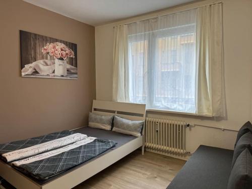 ein kleines Schlafzimmer mit einem Bett und einem Fenster in der Unterkunft Choice Berlin - Wohnung für bis zu 12 Personen in Berlin