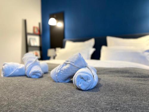 Una cama con toallas enrolladas en azul. en Tic Tac Toe Residence, en Bucarest