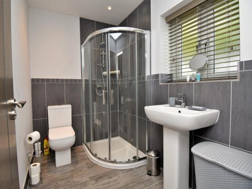 ein Bad mit einer Dusche, einem WC und einem Waschbecken in der Unterkunft 4 Bed in Oswestry 75175 in Kinnerley