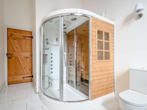 a glass shower in a bathroom with a toilet at 4 bed property in Isle of Bute 85215 in Kilchattan