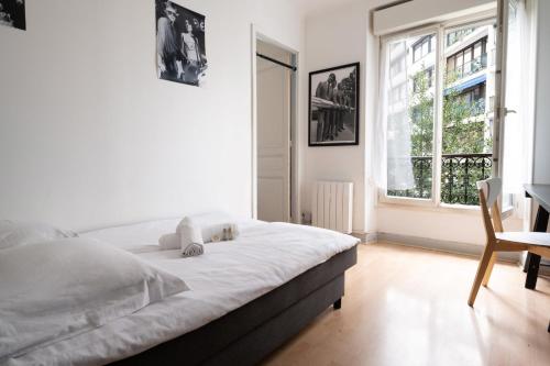 une chambre avec un lit, un bureau et une fenêtre dans l'établissement Appartement Bolivar - Welkeys, à Paris