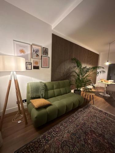 a living room with a green couch and a table at LOFT MANZONI 37 in Cremona