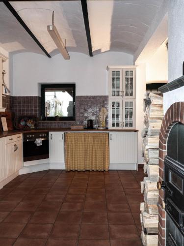 a kitchen with white cabinets and a tv on the wall at Ferienhof Bahlens-Schur in Friedland
