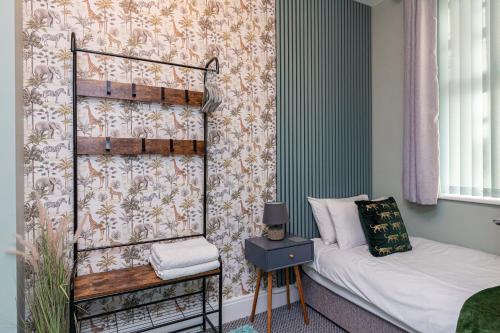 Stylish Seafront 2 Bedroom Apartment - Brand New في موركامب: غرفة نوم بسرير وجدار بالورود