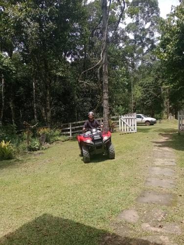 a man riding a quad bike in a yard at Gran Camping Cabanas da Fazenda in Visconde De Maua