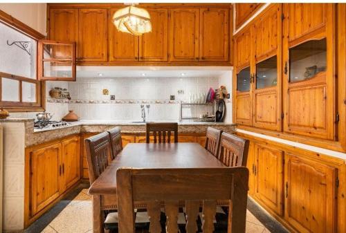 a kitchen with wooden cabinets and a wooden table and chairs at Dar sidi in Rabat