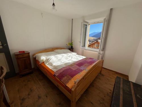 a bedroom with a bed and a window at Sunshine House in Olivone