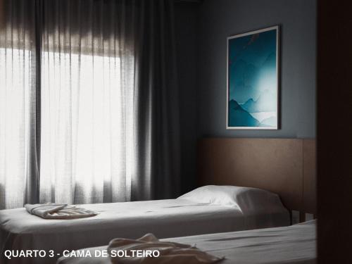 a bedroom with two beds and a window at ApartDamani - Aptos por Temporada no centro in Foz do Iguaçu