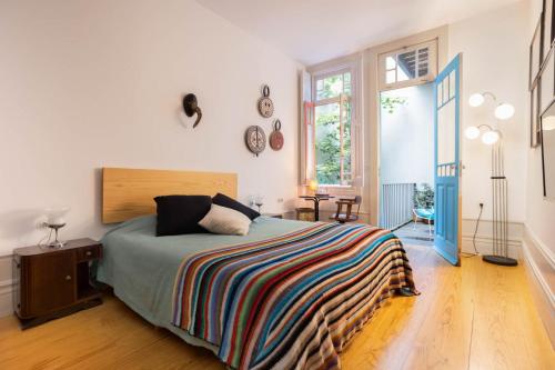 Un dormitorio con una cama con una manta colorida encima. en 14º Esquadra — Cais das Pedras Guest House, en Oporto