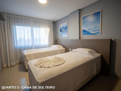 um quarto com duas camas e uma janela em ApartDamani em Foz do Iguaçu