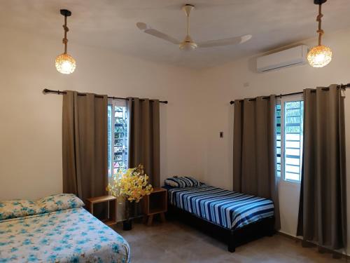 a bedroom with two beds and a ceiling fan at casa flores in Bacalar