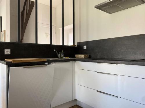 une cuisine avec des armoires blanches et un comptoir noir dans l'établissement Résidence 224-pleneuf Val Andre - Maisons & Villas pour 6 Personnes 704, à Pléneuf-Val-André