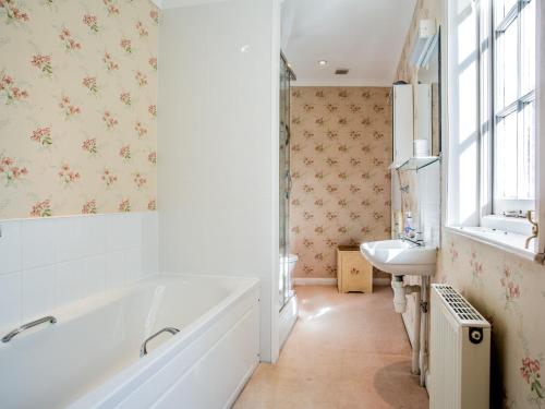 La salle de bains blanche est pourvue d'une baignoire et d'un lavabo. dans l'établissement 4 Bed in Truro 75546, à Ladock