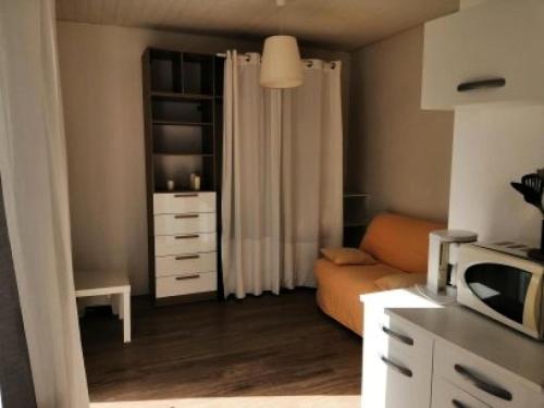 un salon avec un canapé orange dans une cuisine dans l'établissement Résidence 226-pleneuf Val Andre - Charmant studio de 20m², avec jardin privé. MAE-6764, à Pléneuf-Val-André