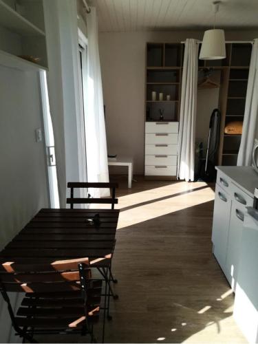 une cuisine avec une table et des chaises dans une pièce dans l'établissement Résidence 226-pleneuf Val Andre - Charmant studio de 20m², avec jardin privé. MAE-6764, à Pléneuf-Val-André