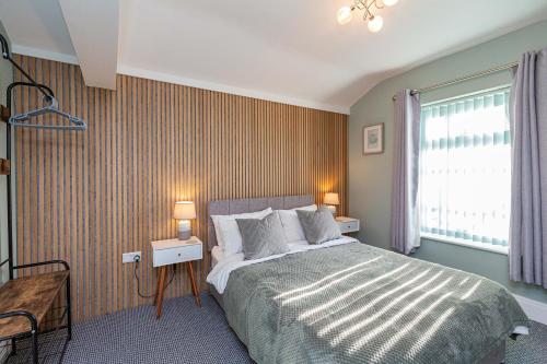 um quarto com uma cama grande e uma janela em Modern Seafront 2 Bedroom Apartment - Brand New em Morecambe