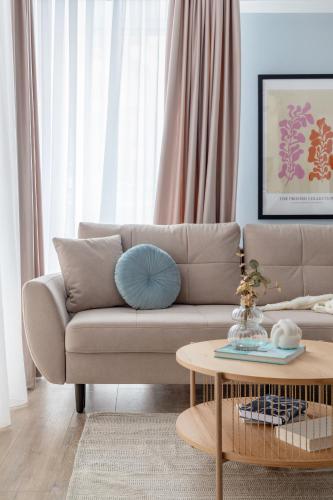 a living room with a couch and a coffee table at Joy Garden Apartment - Free Private Parking - Wellness Jacuzzi SPA Extra Fee in Sinaia