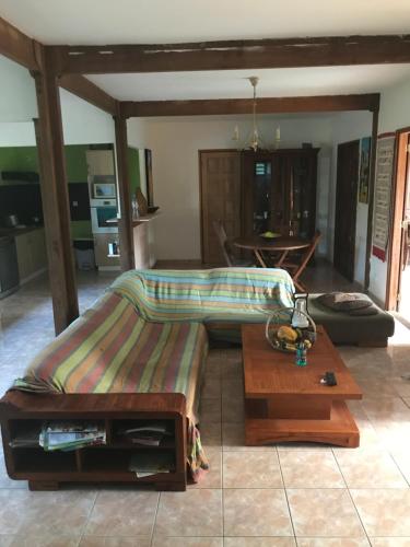 a bed and a table in a living room at Maison Nature in Le Moule
