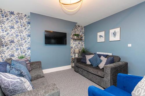 a living room with two couches and a flat screen tv at Seafront Apartment - Sleeps 6 - Gateway to the Lake District - Brand New in Morecambe