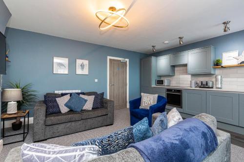 a living room with two couches and a kitchen at Seafront Apartment - Sleeps 6 - Gateway to the Lake District - Brand New in Morecambe