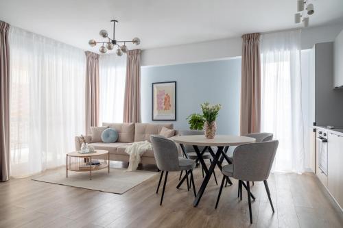 a living room with a table and a couch at Joy Garden Apartment - Free Private Parking - Wellness Jacuzzi SPA Extra Fee in Sinaia