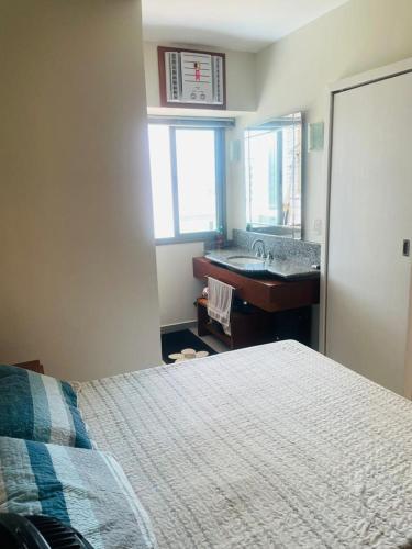 a bedroom with a bed and a sink in it at Flat na praia in Vila Velha