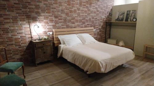a bedroom with a bed and a brick wall at CAN PLANAS , Estudio Familiar in Fonolleras