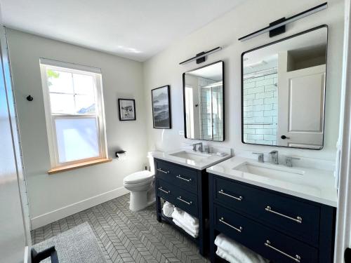 uma casa de banho com um lavatório, um WC e 2 espelhos em Summit Lofts Boutique Hotel em Mount Shasta